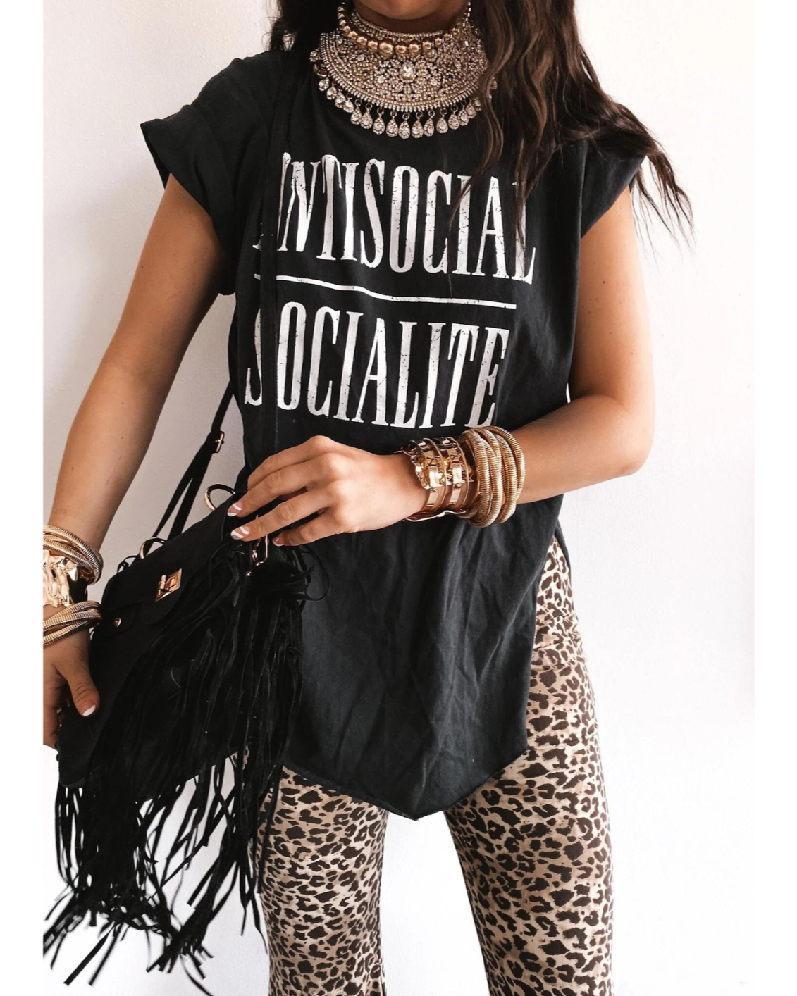 Oversized Anti-Socialite graphic t-shirt draped on hanger with pink background, modern edgy Y2K streetwear style, perfect for soft-launch rich girls.